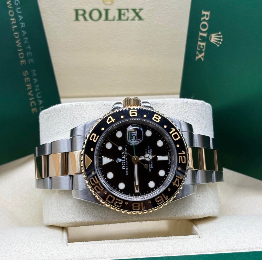 Rolex GMT Master II 116713 laid on its cushion showing the 24 hour Cerachrom bezel and two tone Oyster bracelet