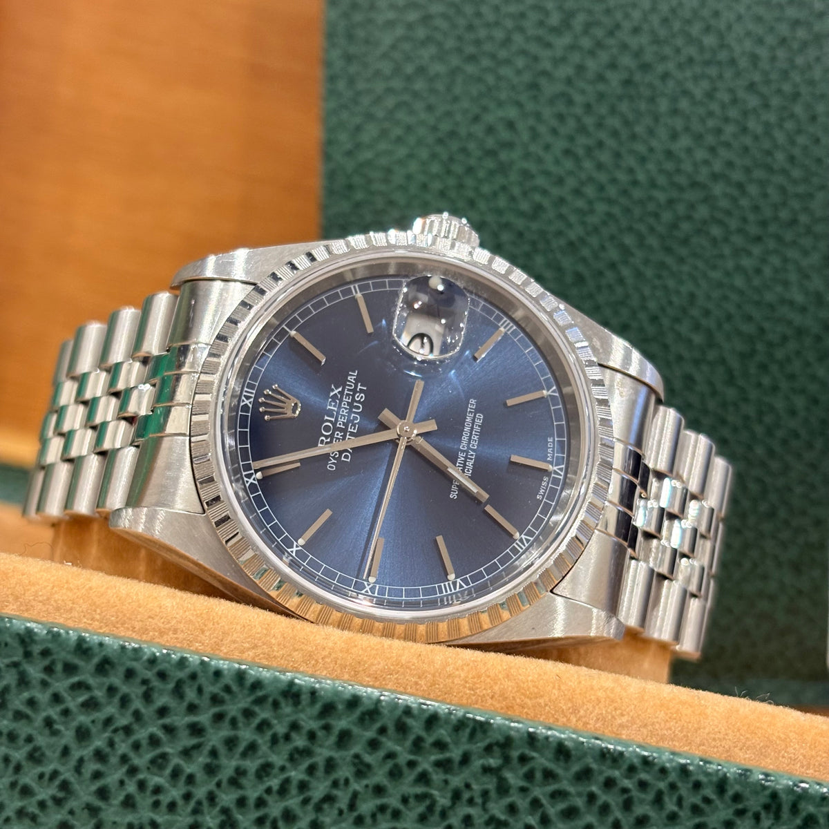 Rolex Datejust 36mm blue dial angled view showing the engine turned steel bezel and date Cyclops