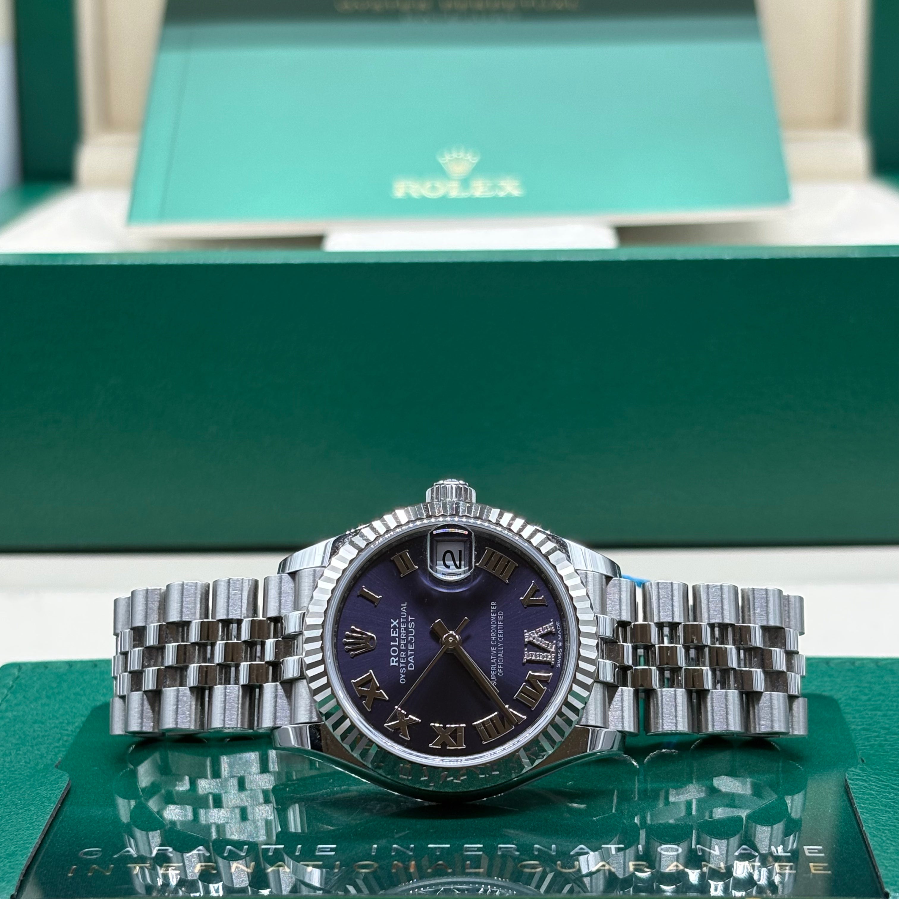 Rolex Datejust 31 ref 278274 aubergine Roman dial laid flat on its International Guarantee wallet at Adonia Jewellers in Yorkville, Toronto