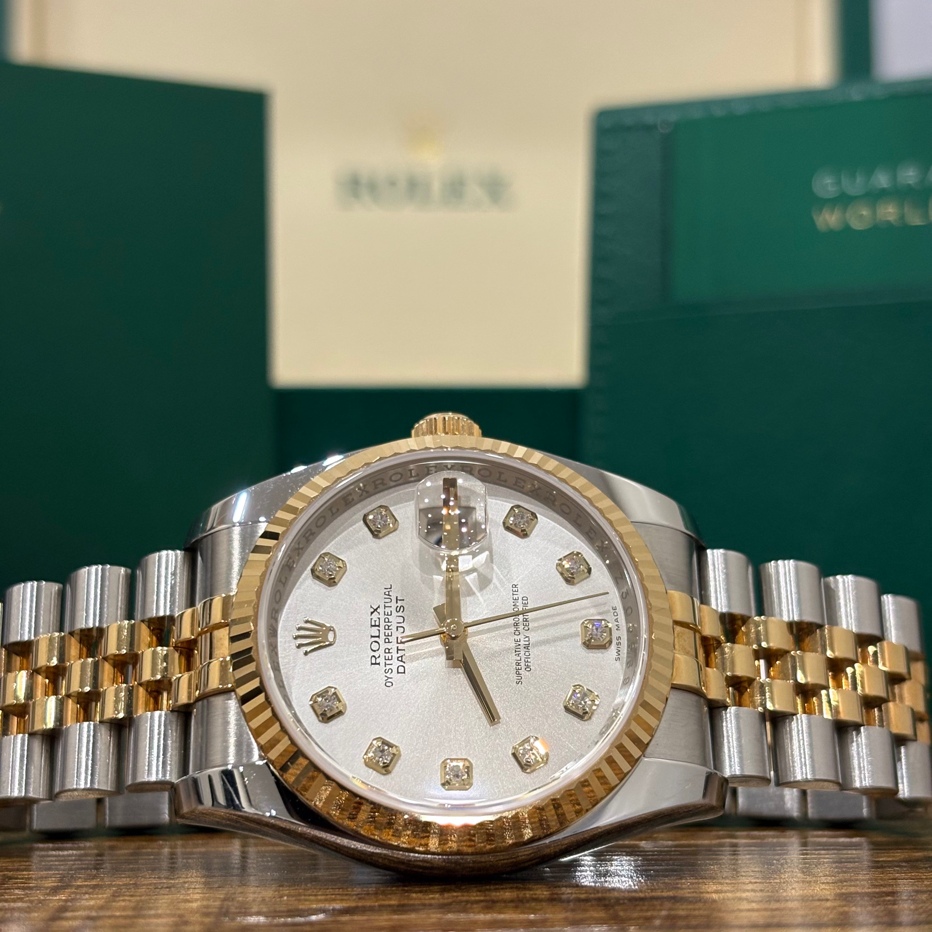 Rolex Datejust 36 two tone silver diamond dial close view of the factory diamond markers and fluted yellow gold bezel