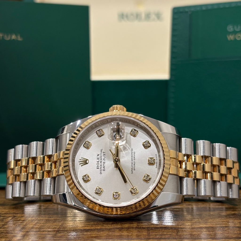 Rolex Datejust 36mm two tone silver sunray diamond dial on Jubilee bracelet with Rolex booklets behind at Adonia Jewellers in Yorkville, Toronto
