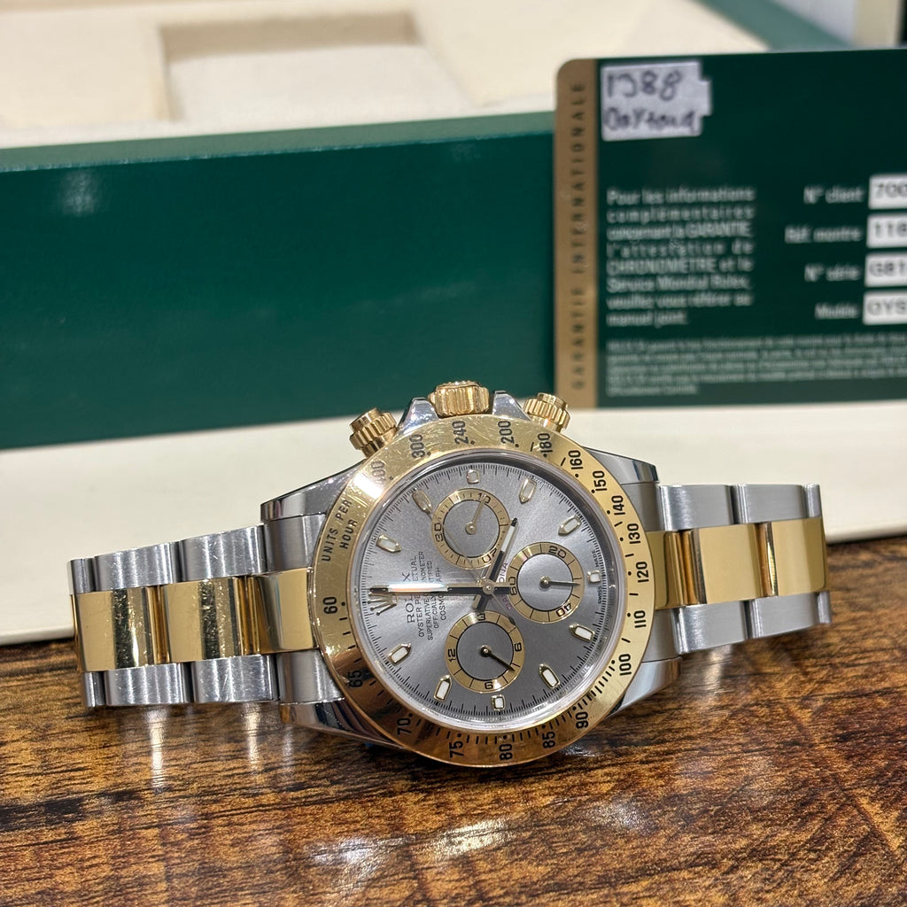 Rolex Daytona 116503 silver dial with gold subdial rings and yellow gold tachymeter bezel, angled view