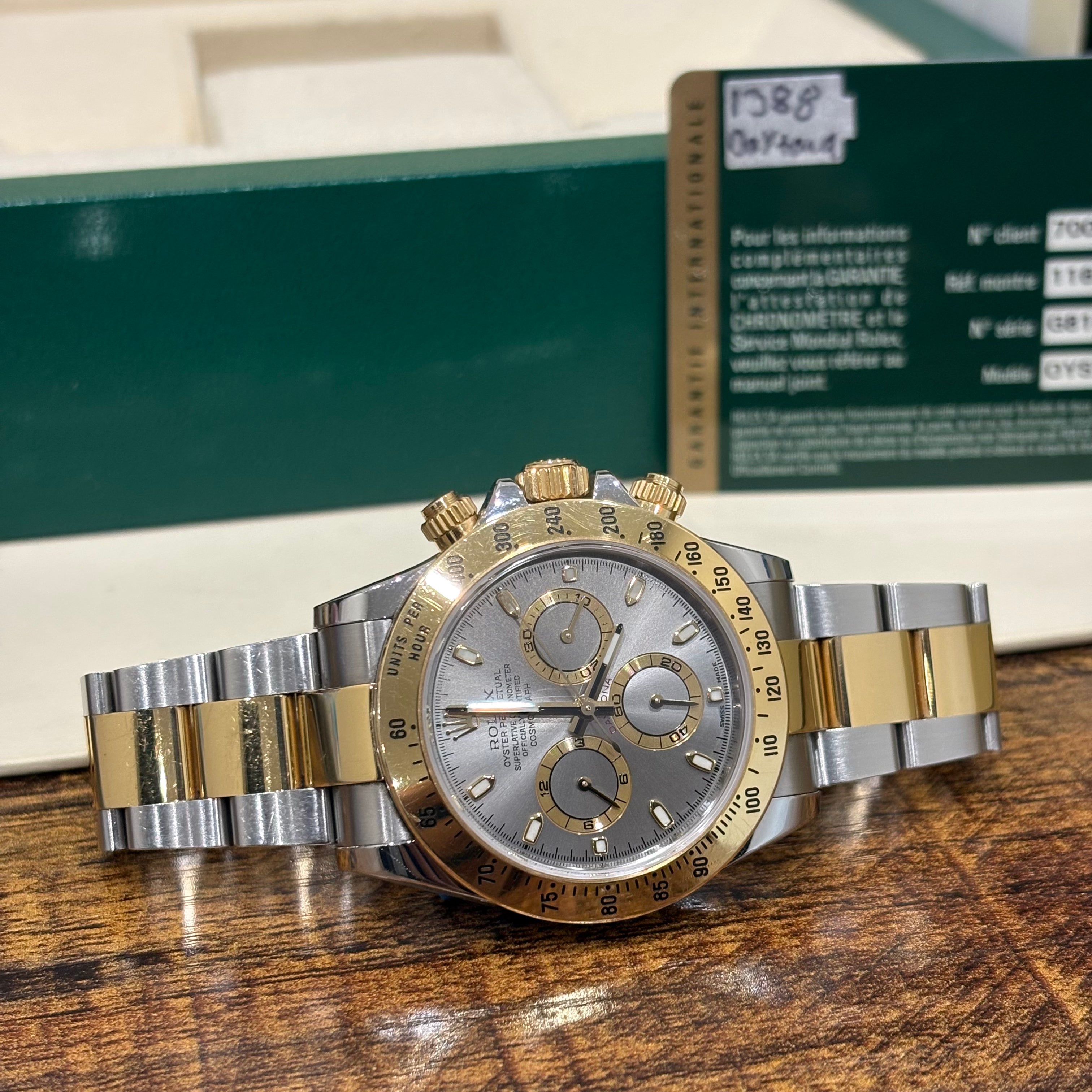 Rolex Daytona 116503 silver dial with gold subdial rings and yellow gold tachymeter bezel, angled view