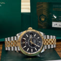 Rolex Sky Dweller 42mm ref 336933 two tone yellow gold black dial on Jubilee bracelet with its 2025 warranty card at Adonia Jewellers in Yorkville, Toronto