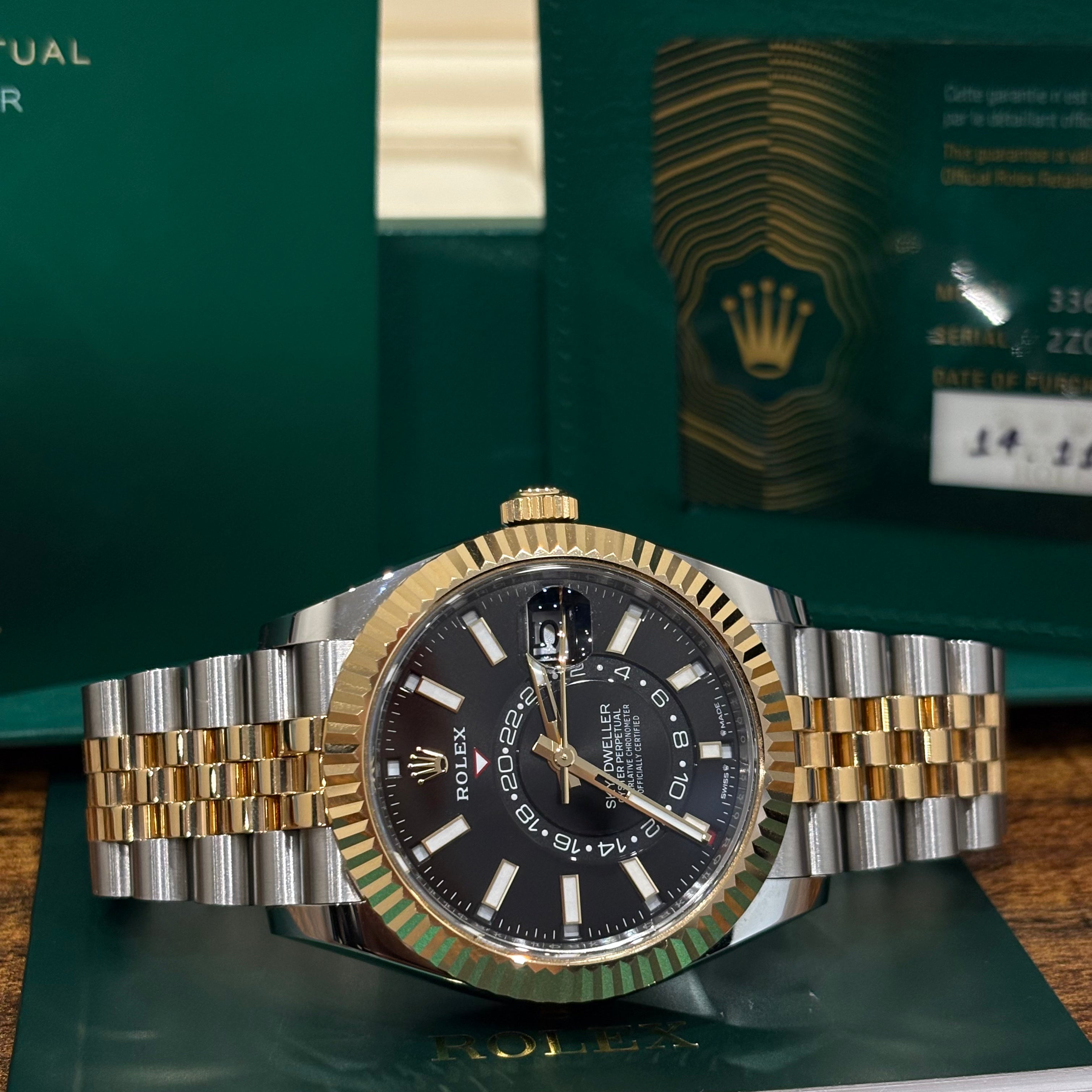 Rolex Sky Dweller 42mm ref 336933 two tone yellow gold black dial on Jubilee bracelet with its 2025 warranty card at Adonia Jewellers in Yorkville, Toronto
