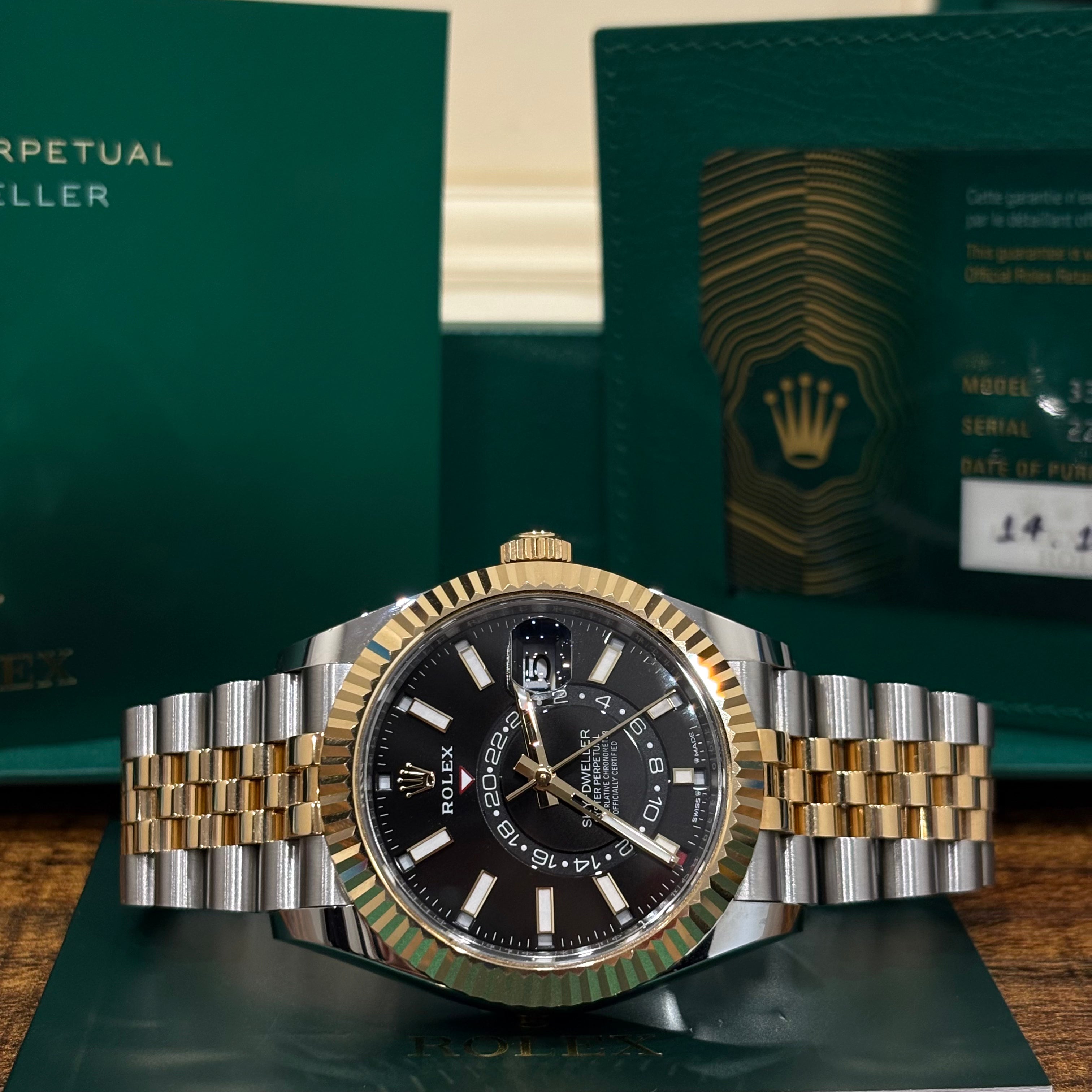 Rolex Sky Dweller 336933 black dial wide view showing the off center 24 hour disc and fluted yellow gold bezel