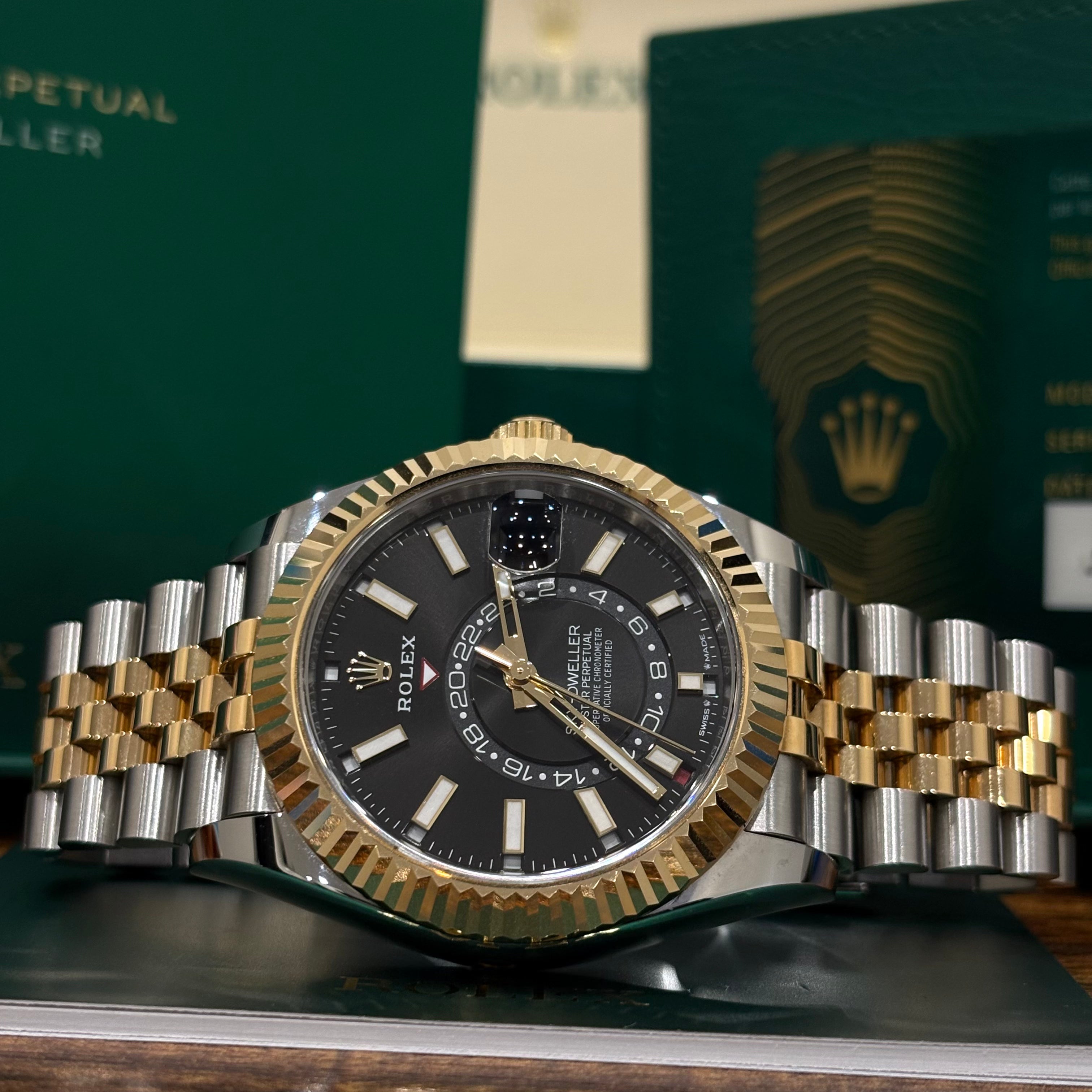 Rolex Sky Dweller 336933 black dial angled view showing the yellow gold crown