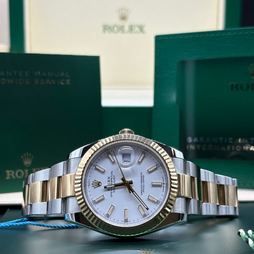 Rolex Datejust 41mm two tone yellow gold white stick dial with fluted bezel on Oyster bracelet, laid flat with its Rolex booklets at Adonia Jewellers in Yorkville, Toronto