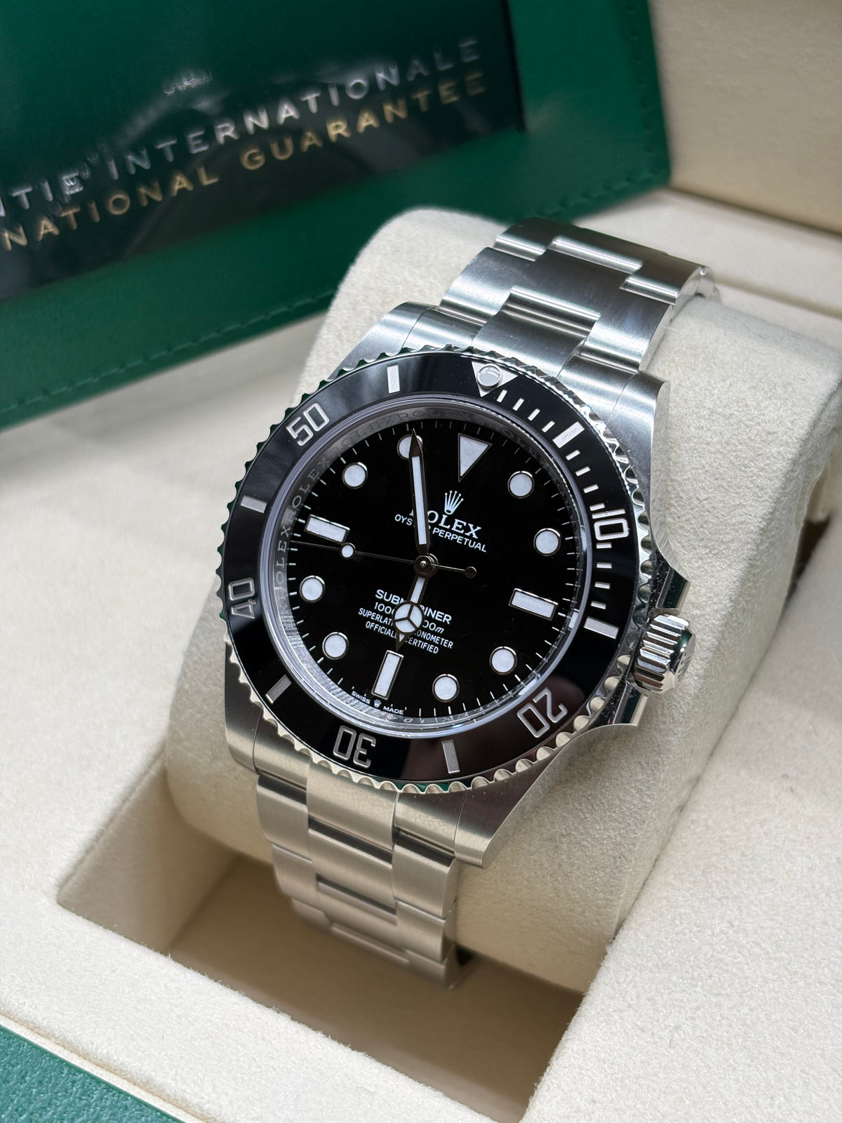 Rolex Submariner 41 black dial angled view with International Guarantee wallet behind