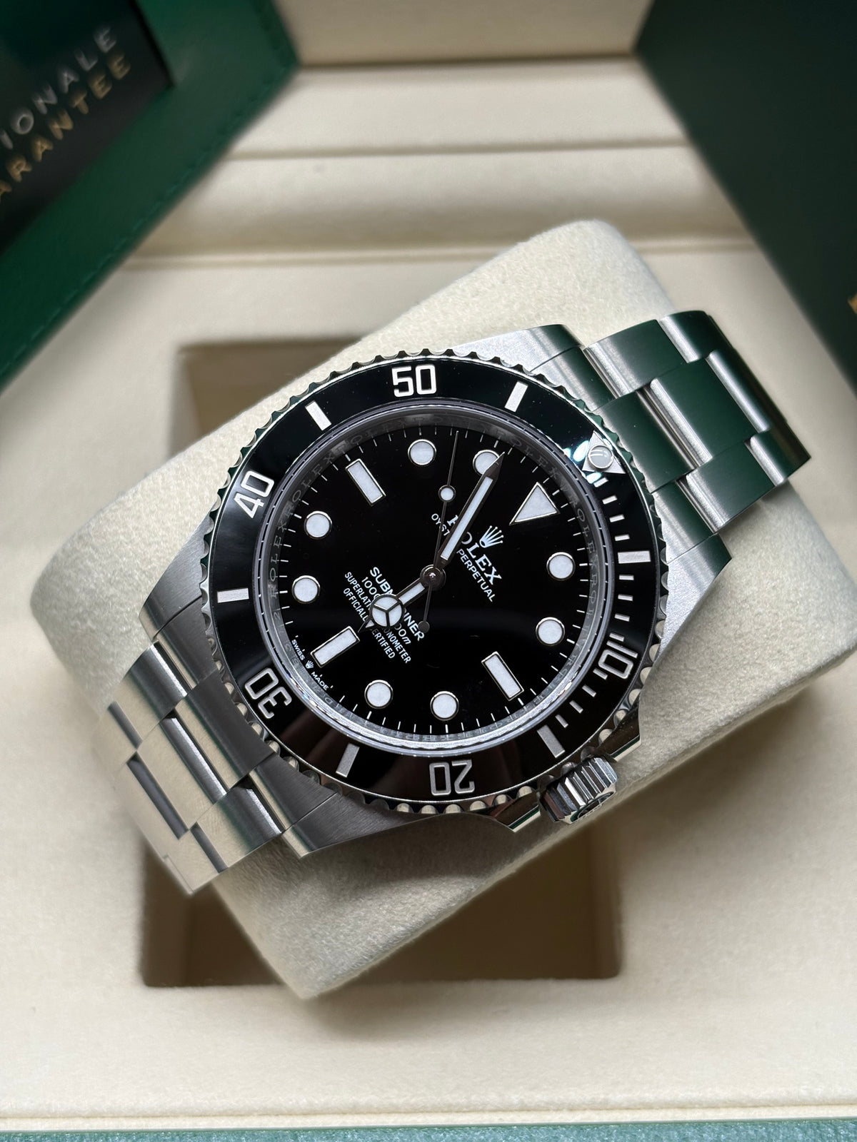 Rolex Submariner 41mm laid on its cushion showing the 60 minute black ceramic bezel and Oyster bracelet