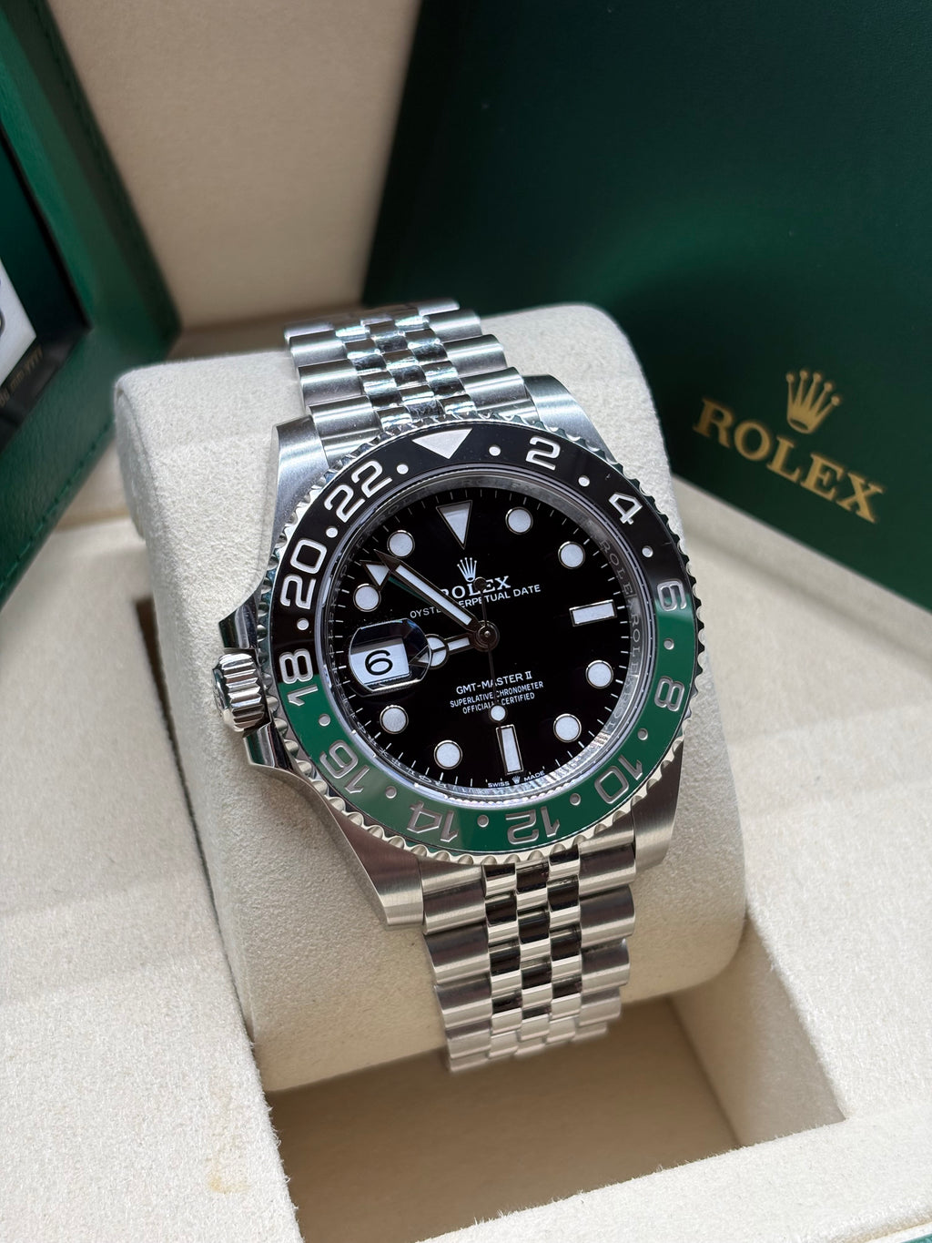 Rolex GMT Master II Sprite front view of the black dial, green GMT hand and left side crown