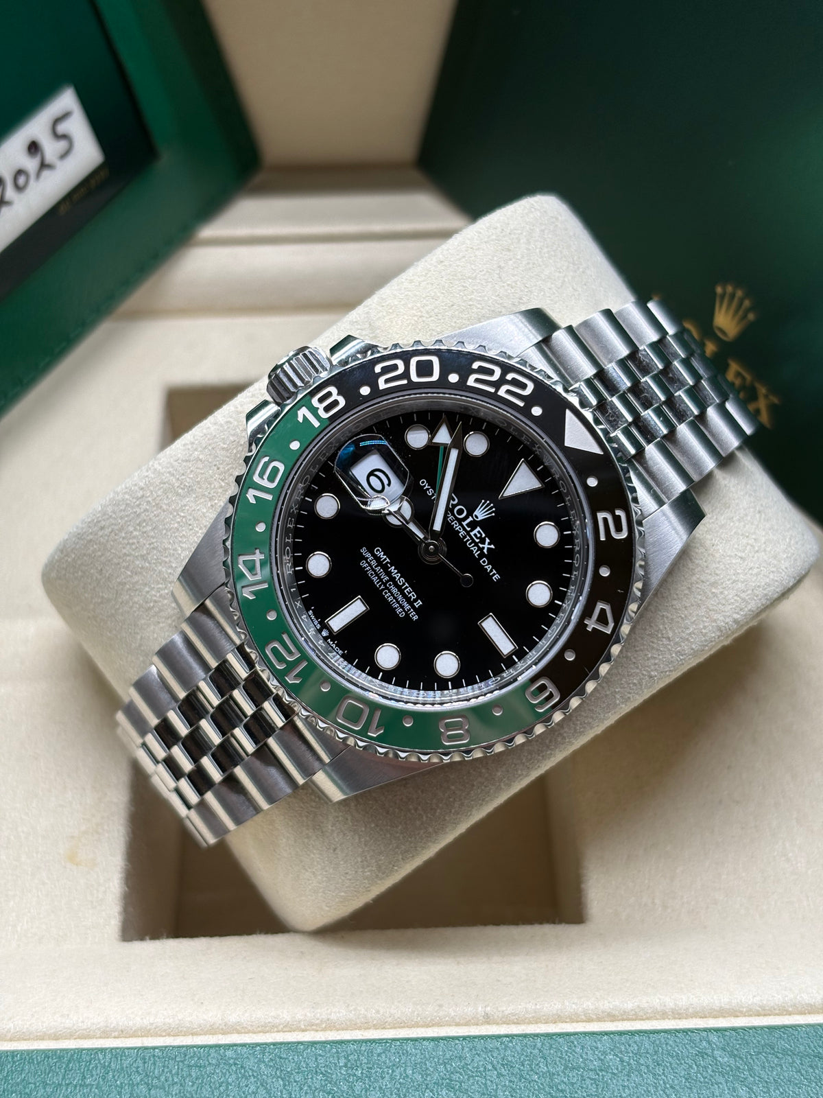 Rolex GMT Master II Sprite laid on its cushion showing the green and black 24 hour ceramic bezel
