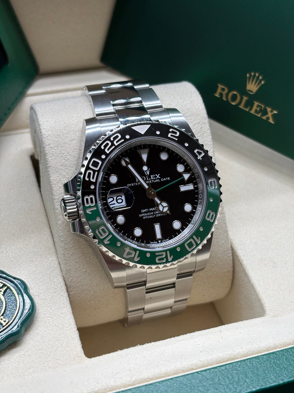 Rolex GMT Master II Sprite front view of the black dial with luminous hour markers and green GMT hand