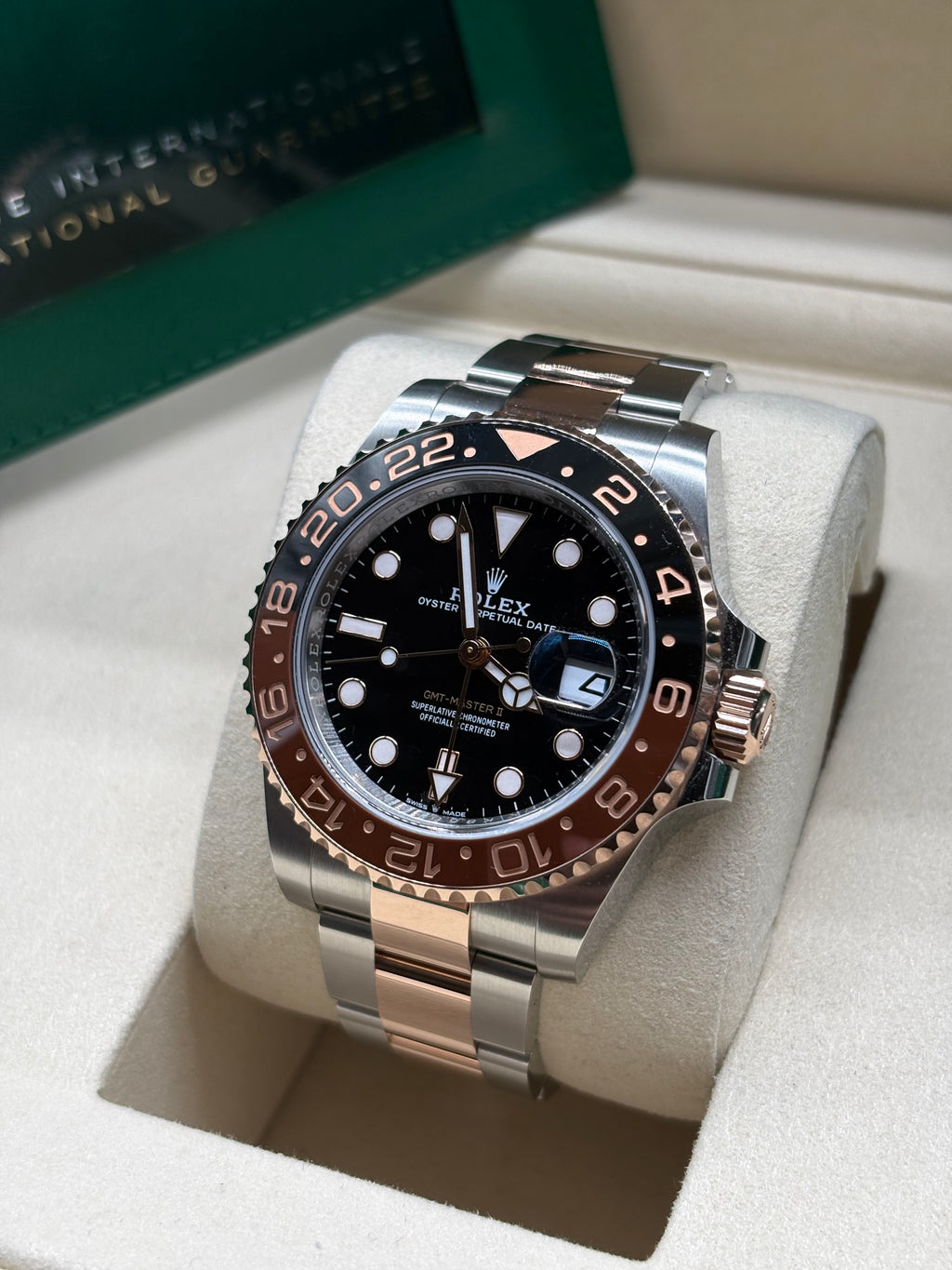 Rolex GMT Master II Root Beer angled view showing the Everose gold crown and date Cyclops