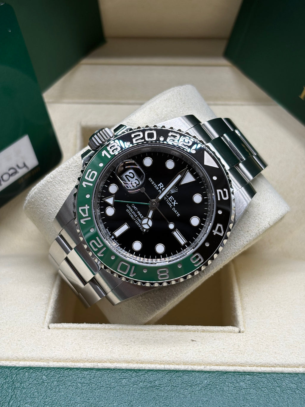 Rolex GMT Master II Sprite laid on its cushion showing the 24 hour graduated bezel and Oyster bracelet
