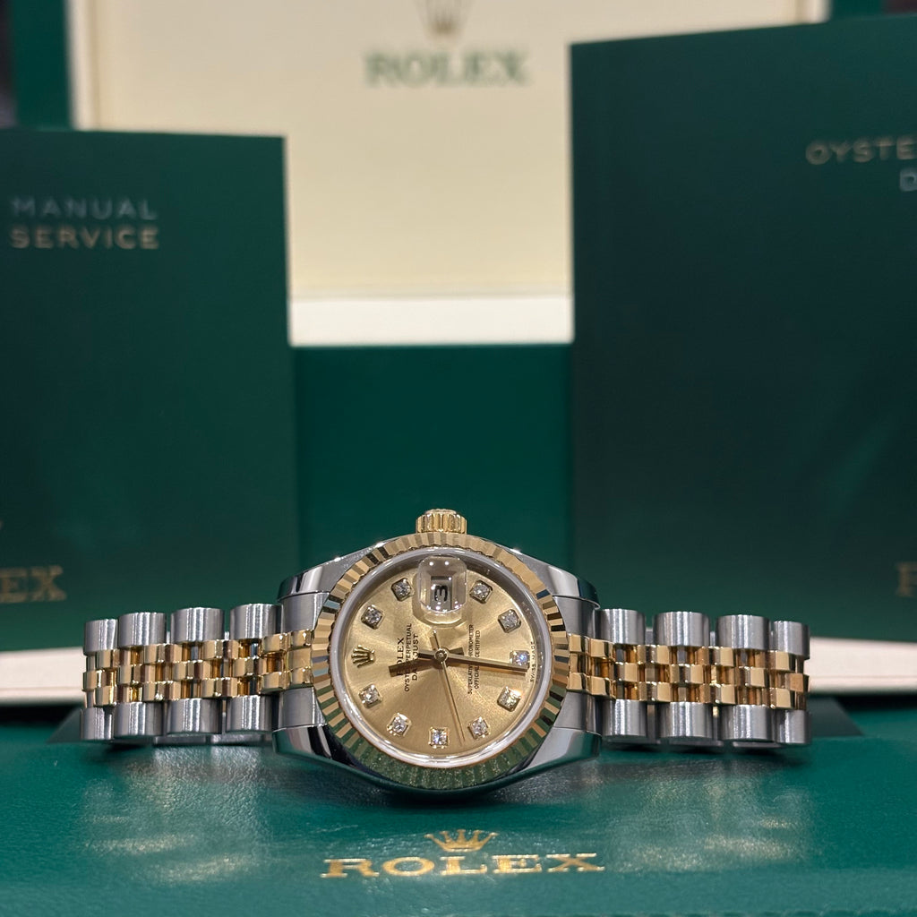 Rolex Lady Datejust 179173 two tone diamond dial resting on its Rolex wallet with booklets