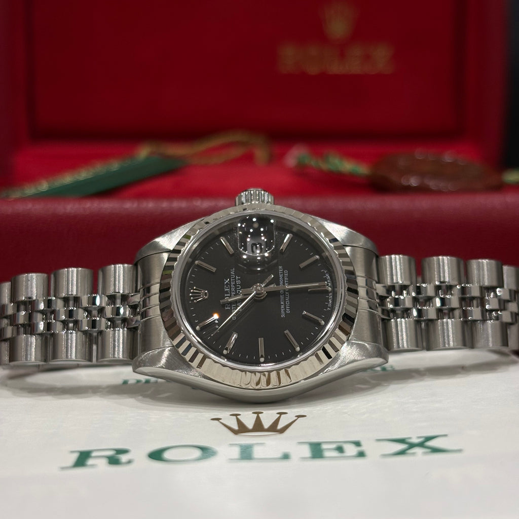 Rolex Datejust 26 69174 close view of the black dial, stick markers and white gold fluted bezel