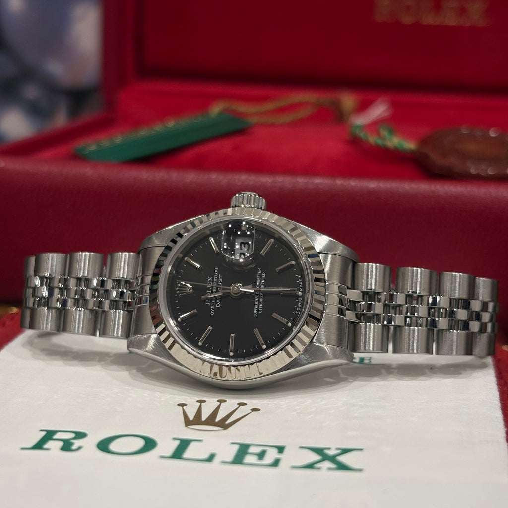 Rolex Lady Datejust 26mm black dial on Oystersteel Jubilee bracelet resting on its Rolex papers