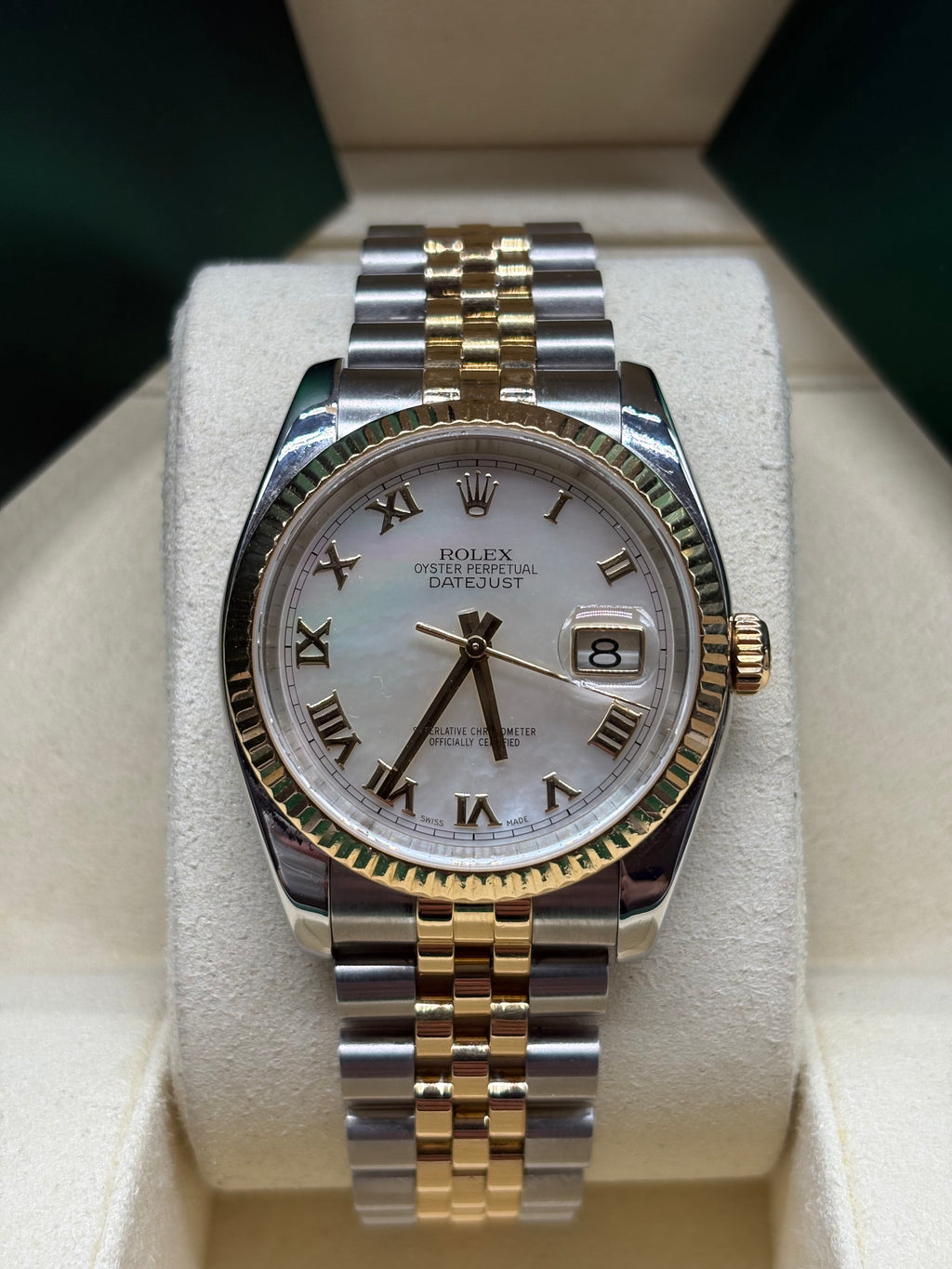 Rolex Datejust 116233 front view of the white mother of pearl dial with yellow gold Roman numerals and fluted bezel