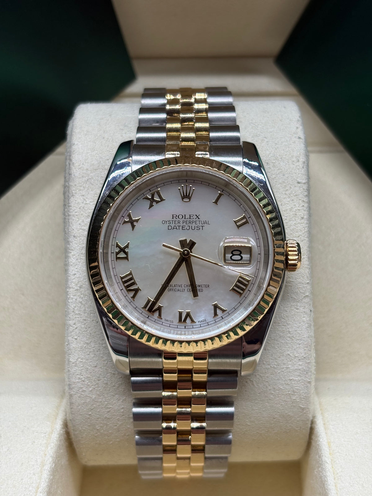 Rolex Datejust 116233 front view of the white mother of pearl dial with yellow gold Roman numerals and fluted bezel