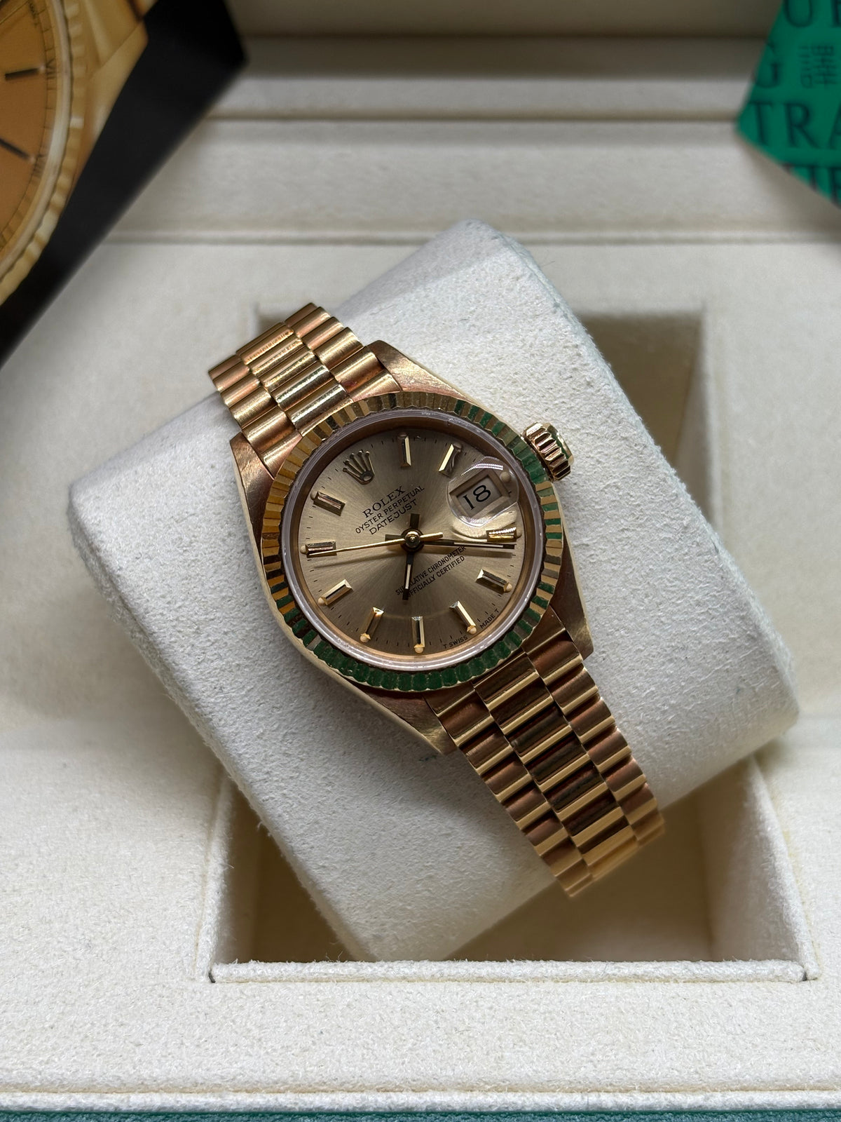 Rolex Lady Datejust 26mm champagne dial angled view on its cushion showing the date Cyclops