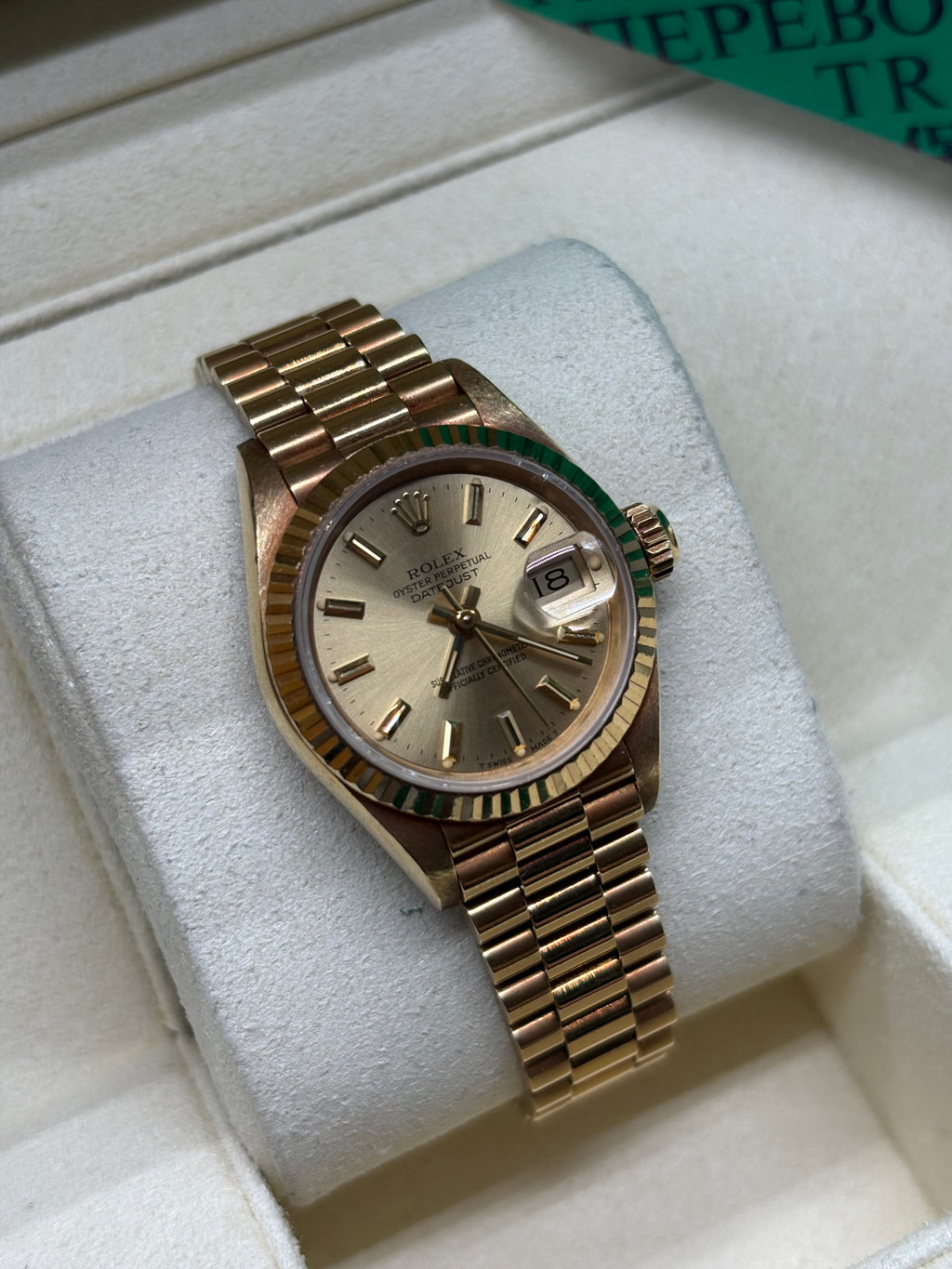 Rolex Lady Datejust 26 champagne dial angled view of the 18K yellow gold fluted bezel and crown