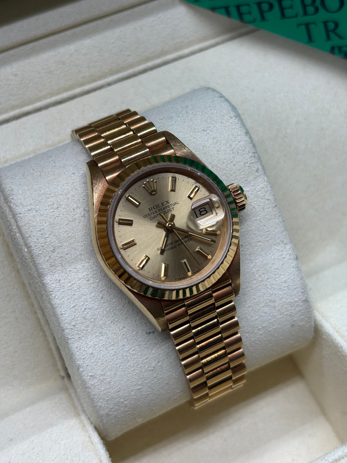 Rolex Lady Datejust 26 champagne dial angled view of the 18K yellow gold fluted bezel and crown