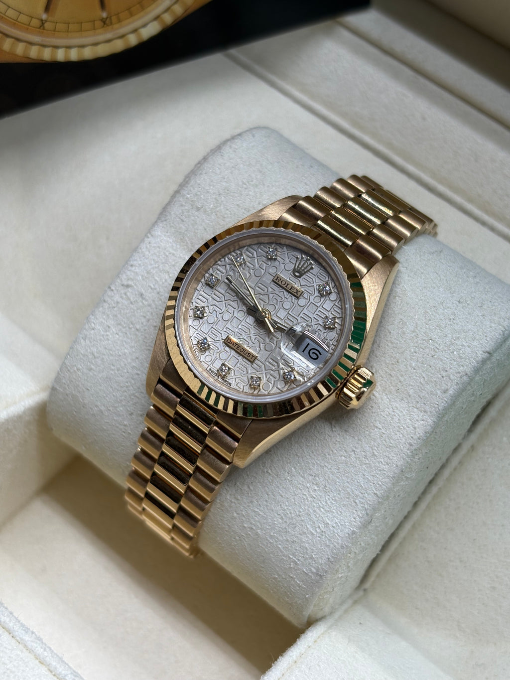 Rolex Lady Datejust 26mm silver diamond dial angled view showing the fluted yellow gold bezel and crown
