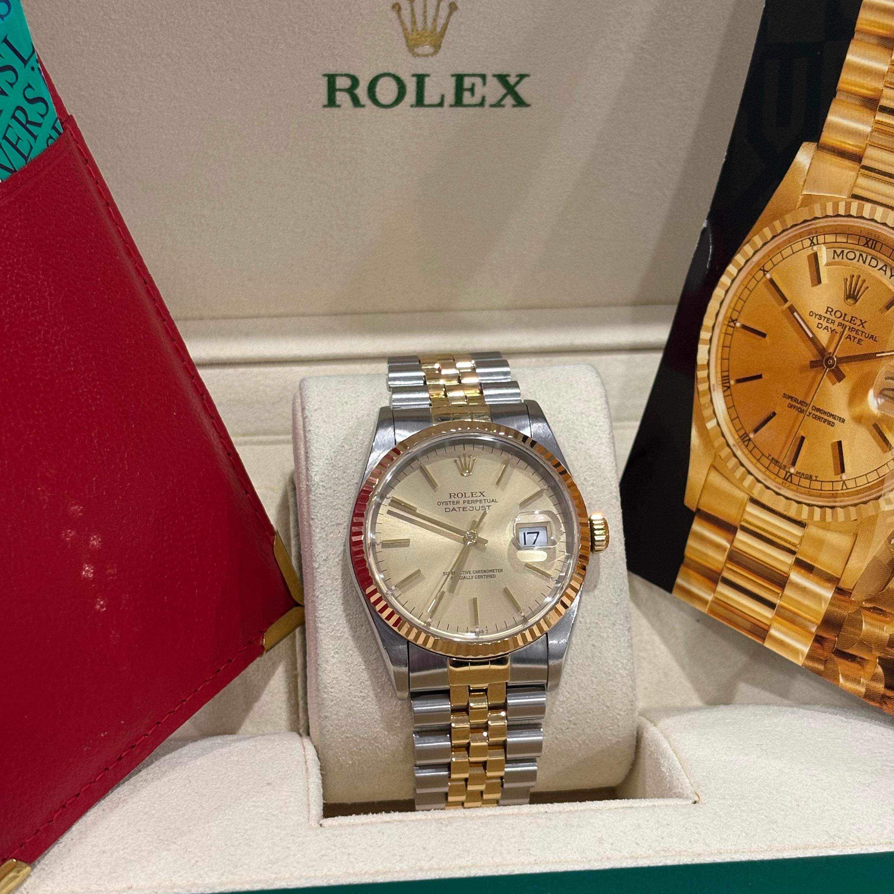 Rolex Datejust 36 champagne dial front view in its Rolex box beside the red Rolex wallet