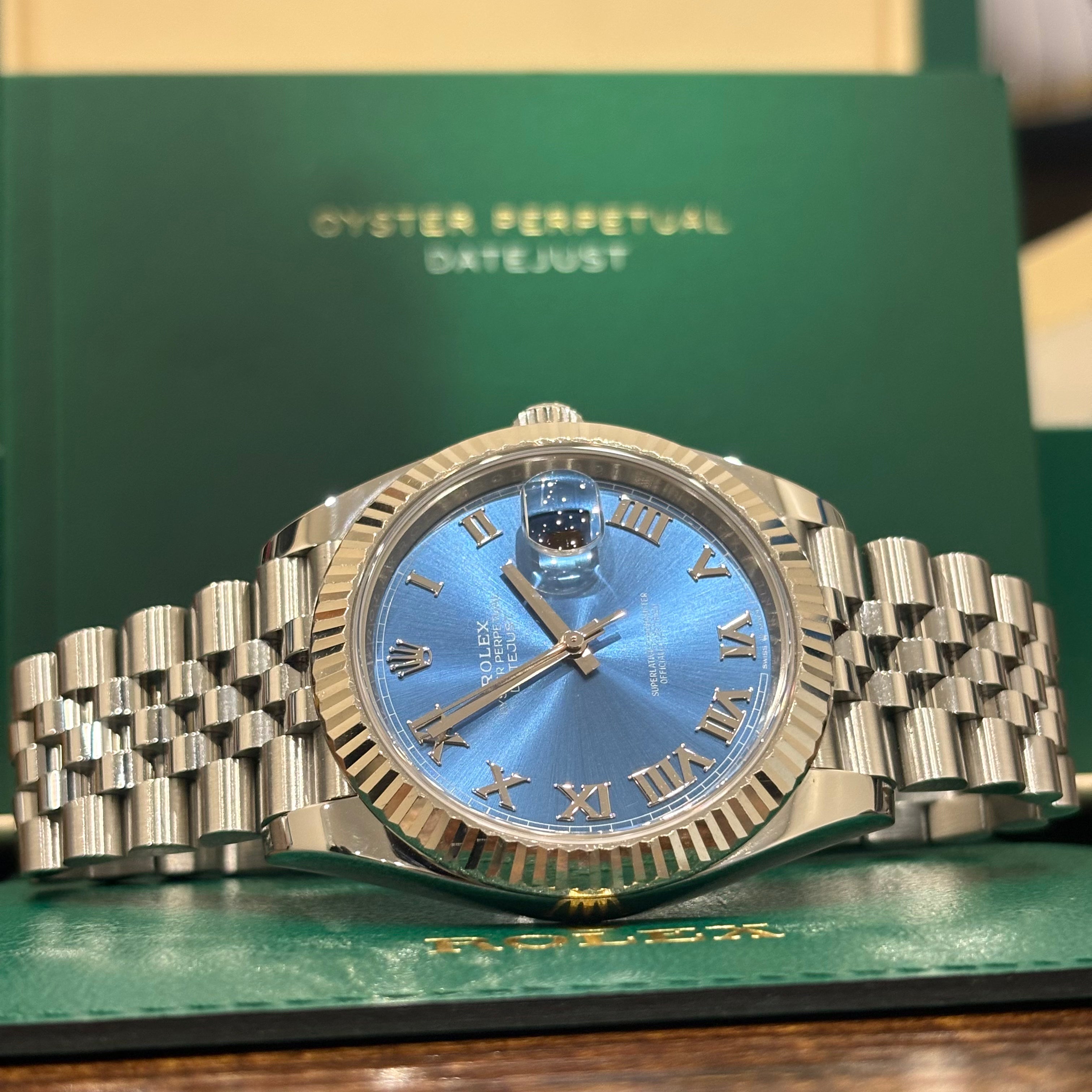 Rolex Datejust 41 126334 Azzurro blue dial wide view in front of the Datejust booklet