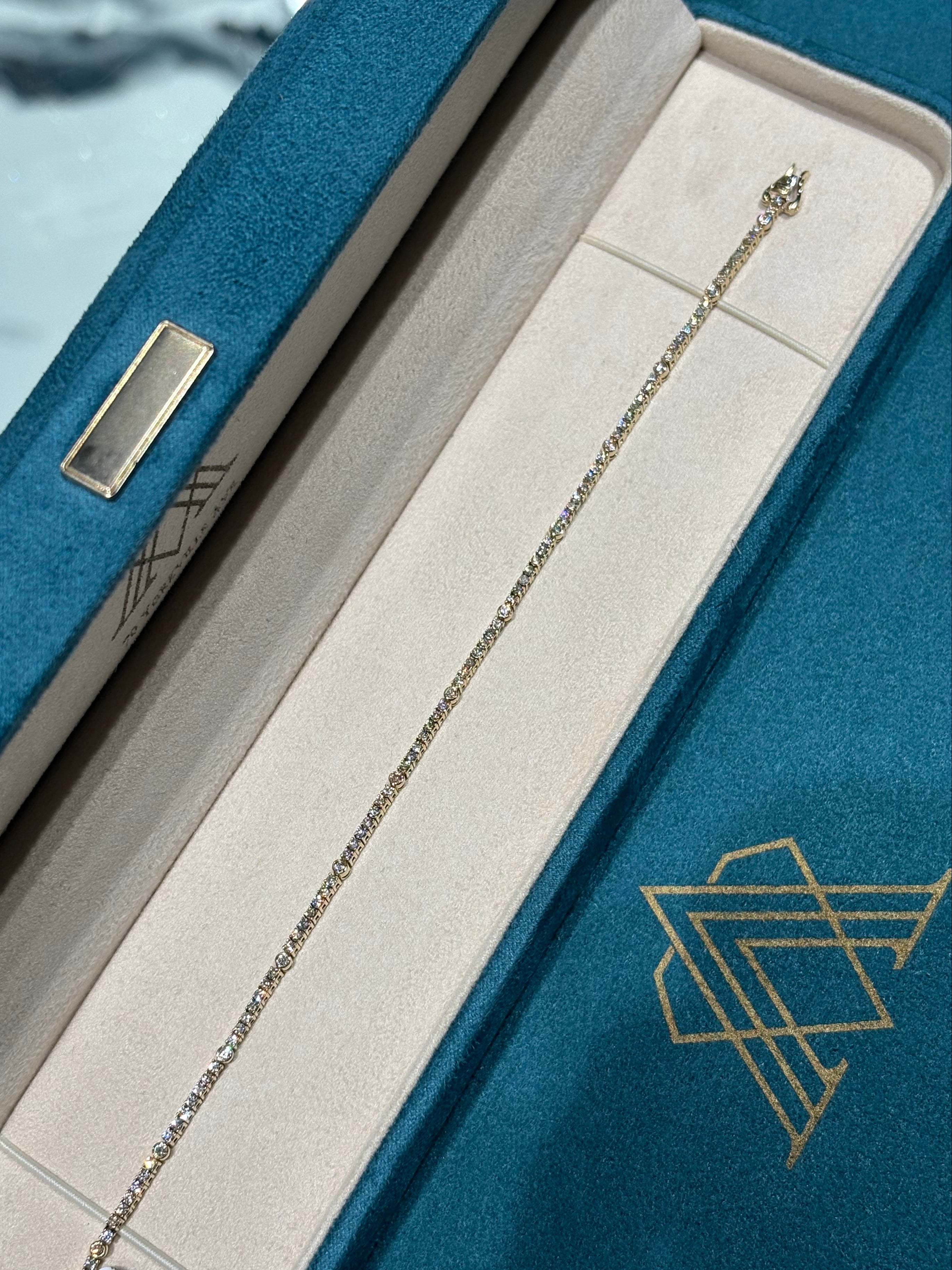 Gold necklace in an open jewelry box with a visible brand logo.