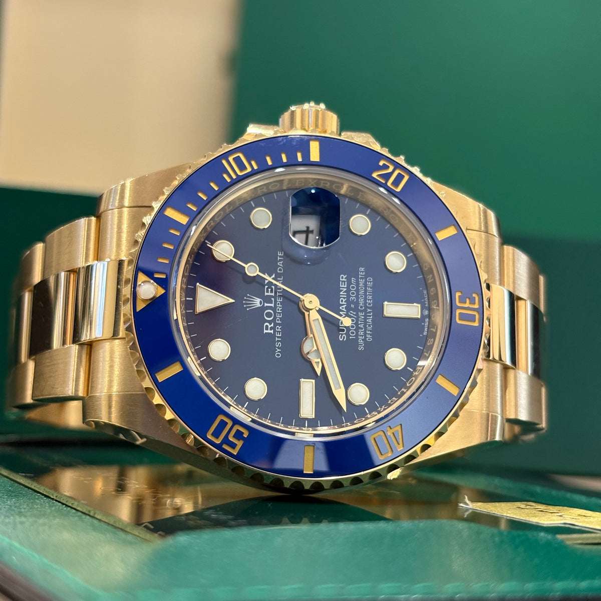 Rolex Submariner Date 41 yellow gold close view of the blue ceramic bezel and screw down crown